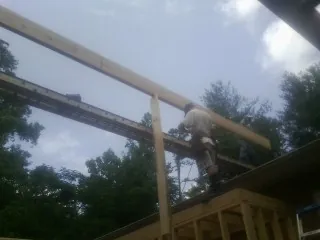 Carpenter setting a ridge beam over a new addition frame — Ice Dam Removal by Roofing Brothers in Madison Lake