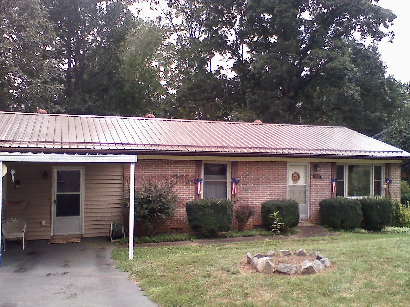 Bronze metal roof and carport on a brick ranch home — Roof Repair work by our crew in Madison Lake