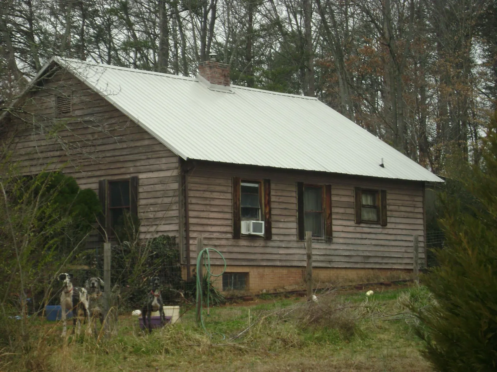 White metal roof on an old wood sided farmhouse, from a Metal Roof Installation job in Madison Lake